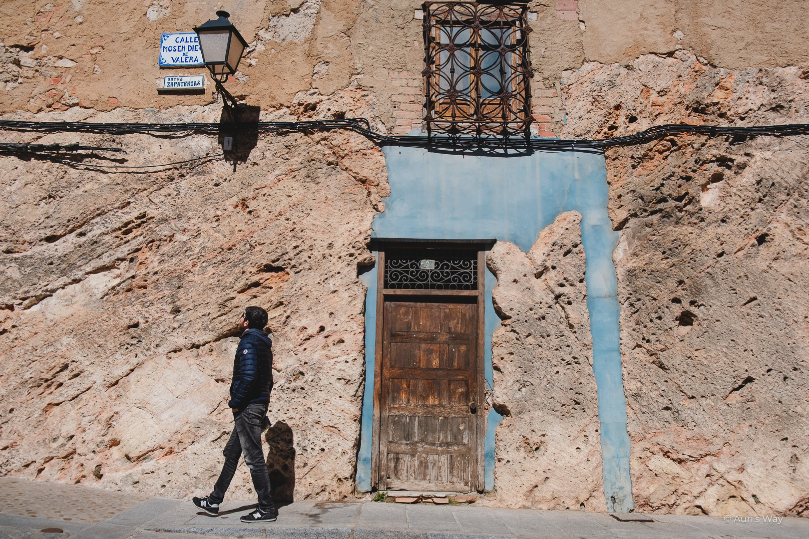 Homme passant devant une vieille bâtisse en pierre à Cuenca.