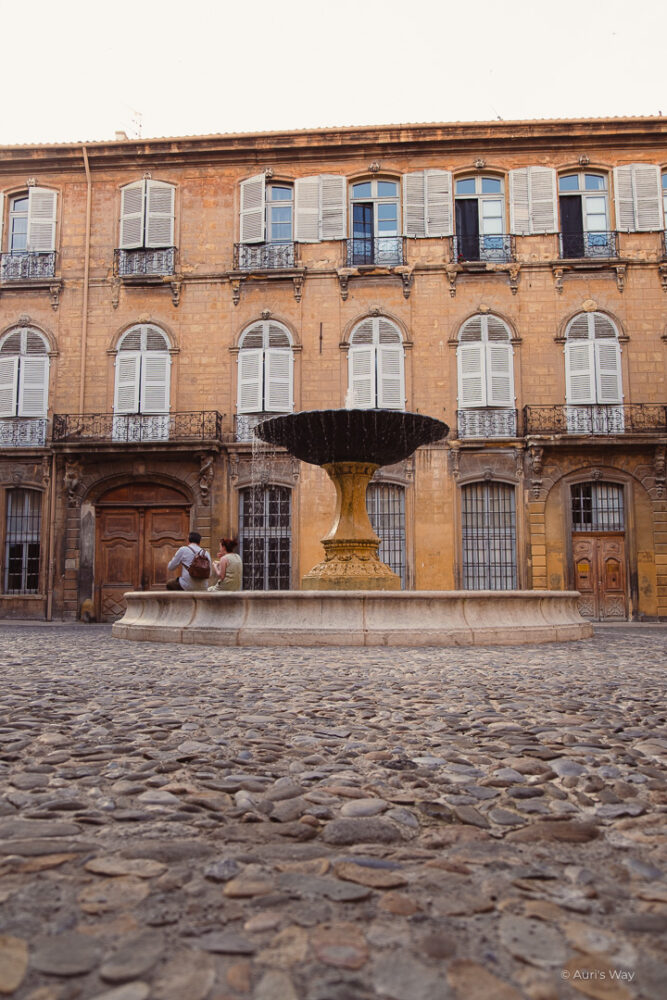 Fontaine de la place d'Albertas à Aix-en-Provence avec les pavés au sol au premier plan.