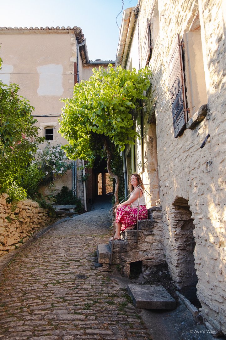 Femme assise dans une ruelle provençale pittoresque à Gordes