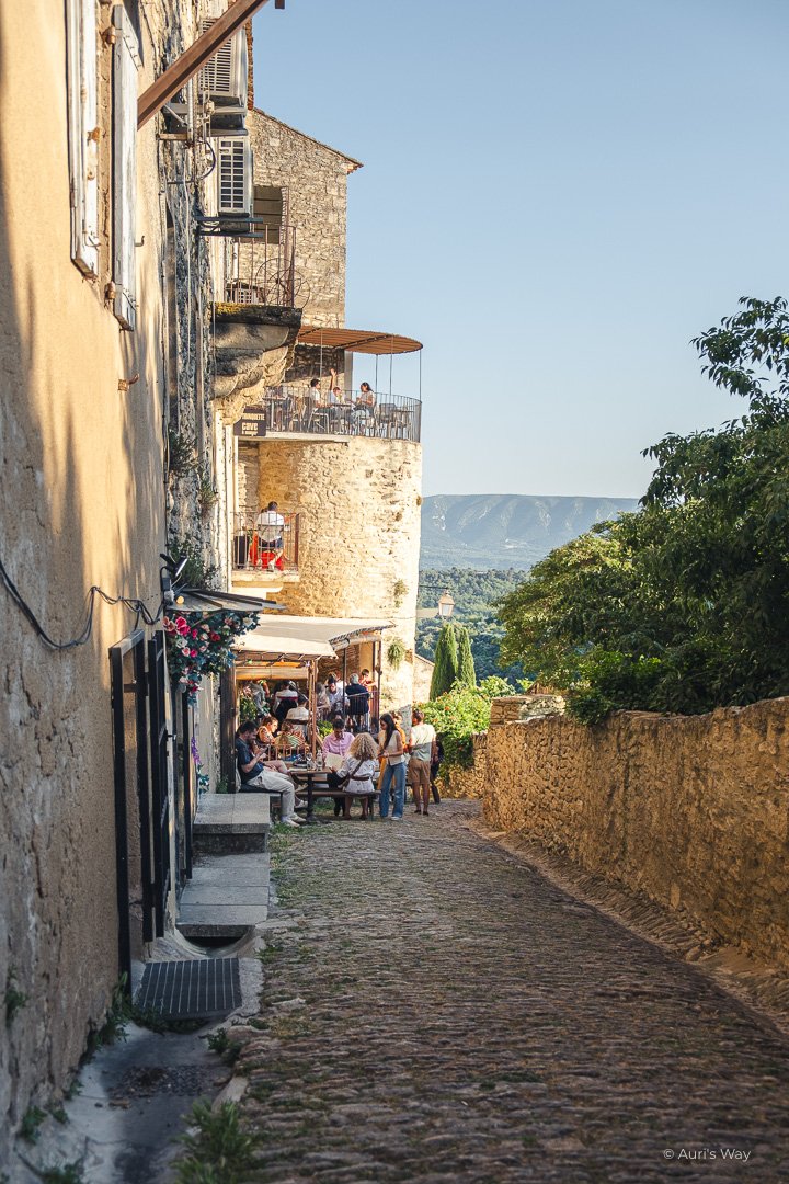 Ruelle médiévale avec restaurant animé dans le village de Provence de Gordes